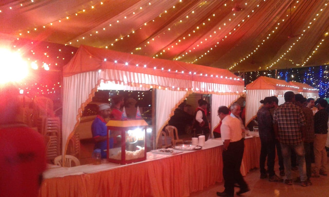 Live food stalls under fairy-light tent at an event by Red Q Events